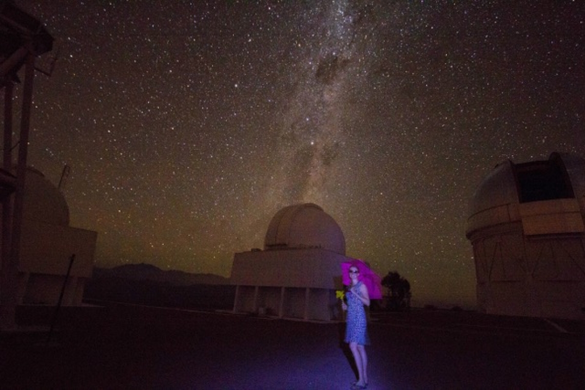 Woman at night in front of telescope Woman at night in front of telescope
